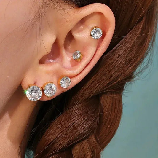 Close-up of ear wearing multiple 18k gold plated stud earrings with clear sparkling stones
