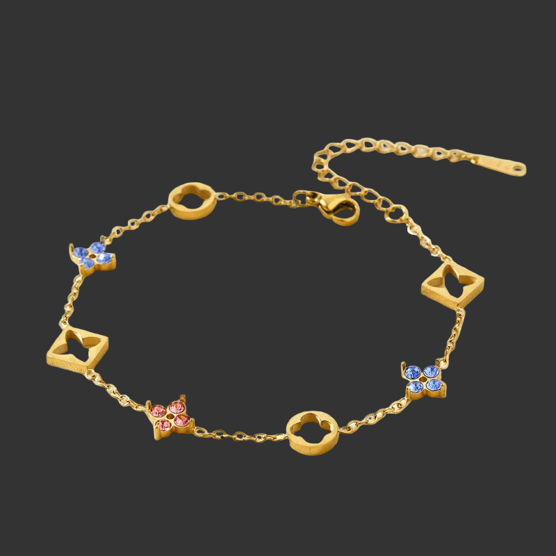 Gold bracelet with four leaf clover and star-shaped charms on a black background