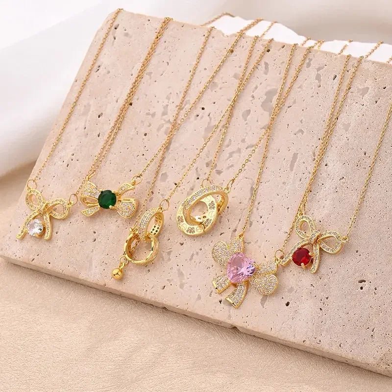 Gold necklaces with various pendants displayed on beige stone surface double ring pendant necklace gift