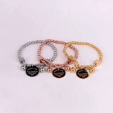Set of three bracelets in different colors with engraved text on a white background