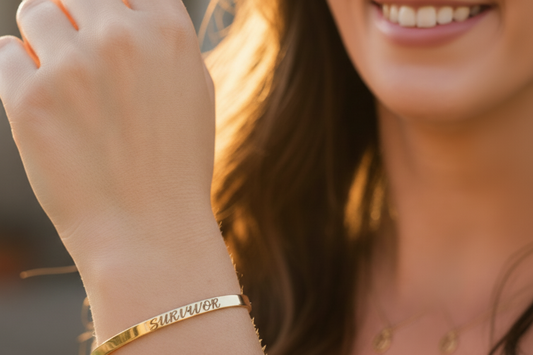 A close-up lifestyle shot of a woman's wrist wearing a gold band engraved bracelet.