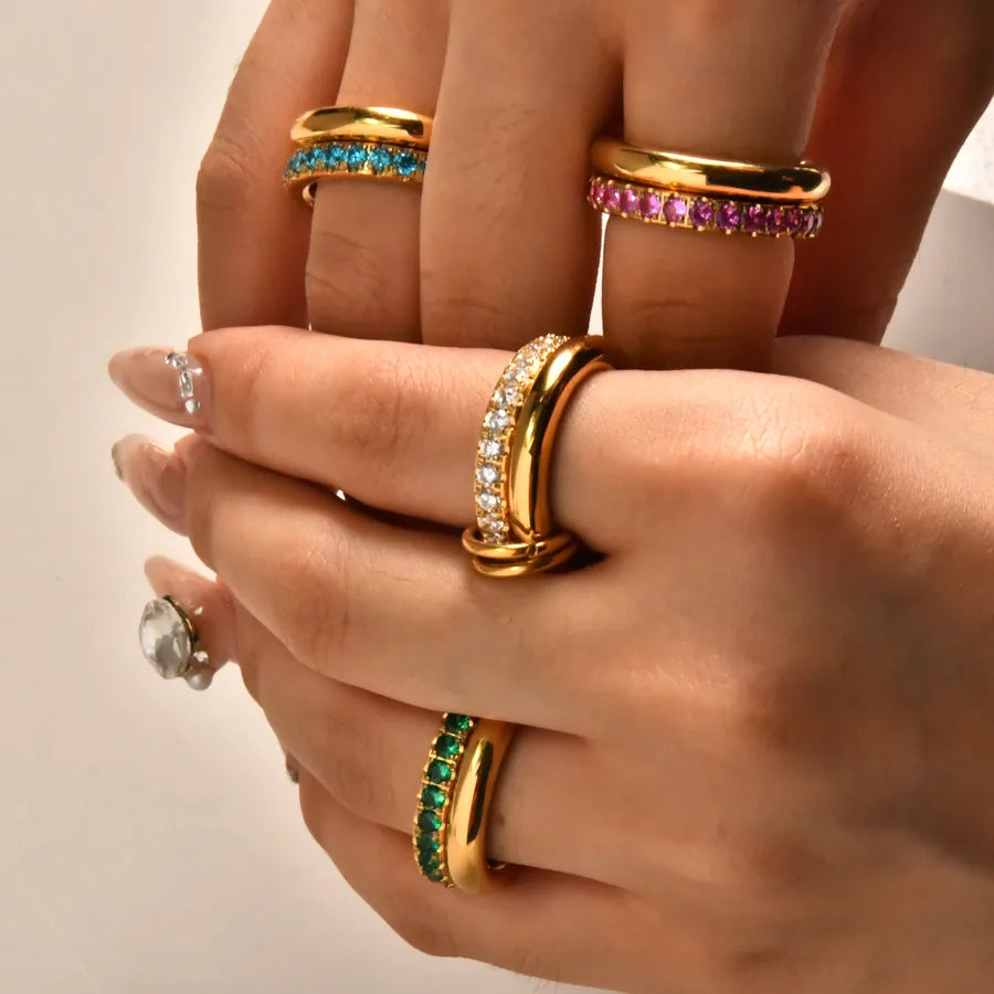 tattooed wrist on hand holding Christmas card with thumb wearing gold 2 headed panther open ring with clear stones on heads and green stones for eyes and blurred Christmas tree in background