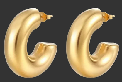 Gold hoop earrings on a black background