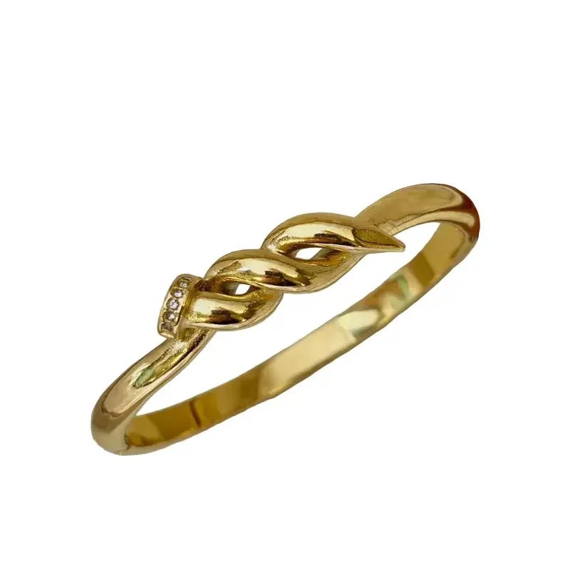 18K gold plated bracelet for women with twisted nail design and small embedded crystals on a white background