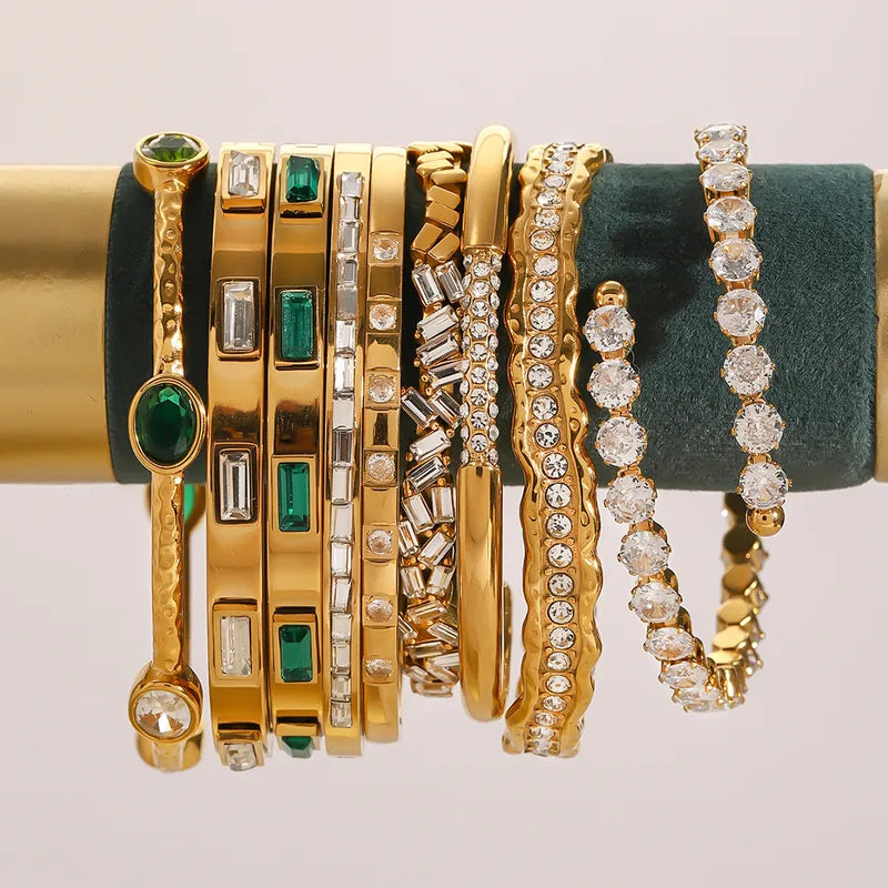 Collection of gold and diamond bracelets on a stand with a neutral background