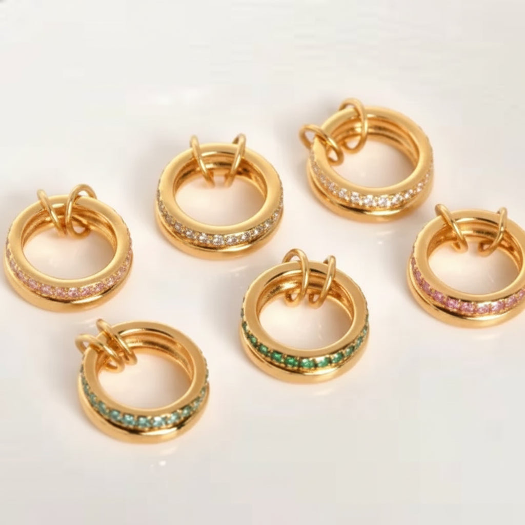 Gold linked rings with various color gemstones on a white background