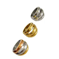 Three metallic rings in gold, silver, and mixed metal on a white background