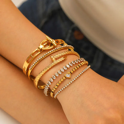 Gold bracelets with intricate designs on a wrist