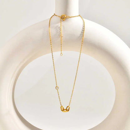 Dainty 3 interlocked links pendant on  a white circular decor piece.