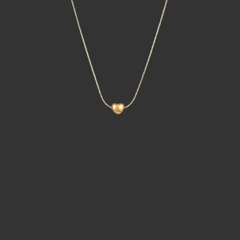 Gold heart-shaped pendant necklace on a black background