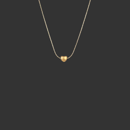 Gold heart-shaped pendant necklace on a black background