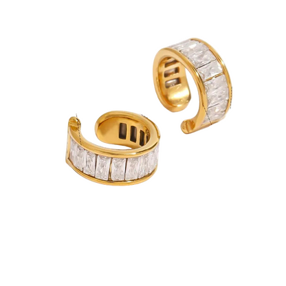 2 Gold ear cuffs with gemstones on a white background