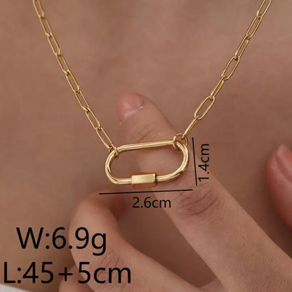 Gold chain necklace with carabiner pendant held by a hand with measurements displayed.