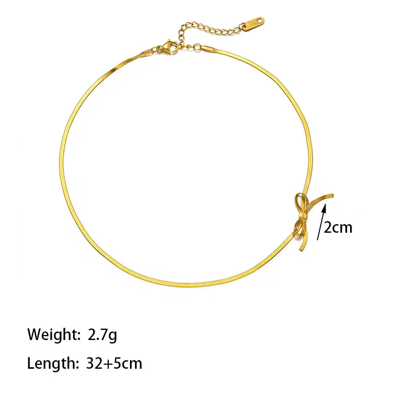 Gold necklace with bow detail on a white background with measurements 
