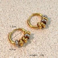 Gold and silver hoop earrings with measurements and weight details on a beige background