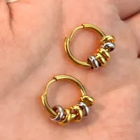 Gold and silver hoop earrings on a hand