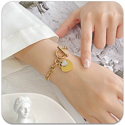 Gold bracelet with heart charms on a wrist against a white background