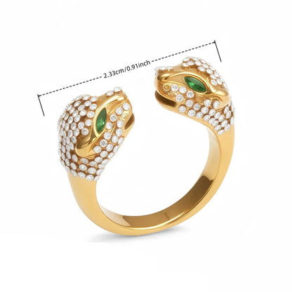 Gold open ring with double panther head design and green stones for eyes with clear stones covering each head on a white background with measurements 