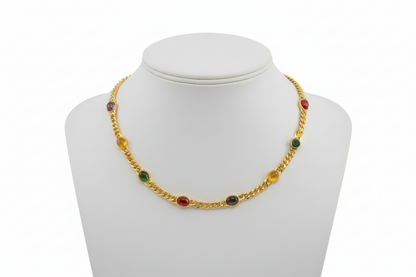 Gold necklace with colored beads on a white mannequin bust