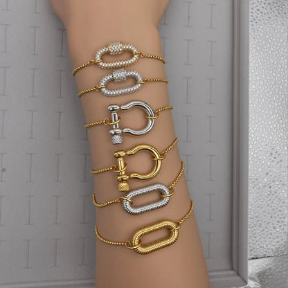 Multiple gold and silver bracelets on a wrist against a neutral background