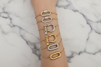 Set of gold, silver, and rose gold bracelets on a marble surface