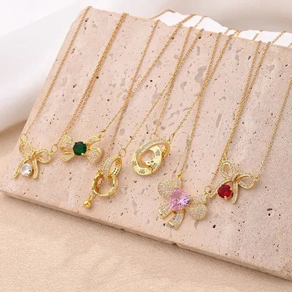 Gold necklaces with various pendants displayed on beige stone surface double ring pendant necklace gift