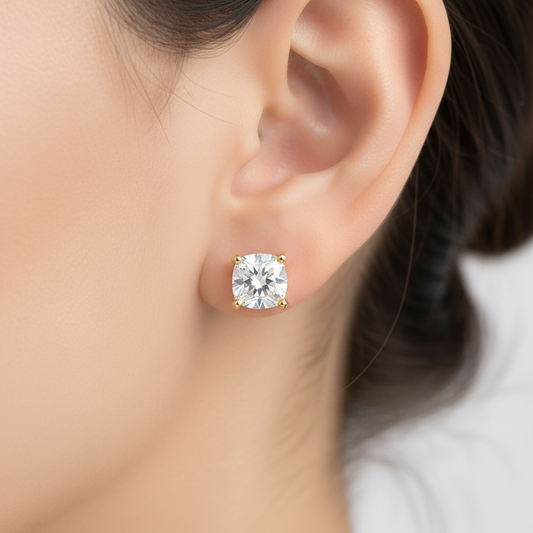 Gold earring with a clear gemstone worn by a person