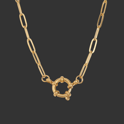 gold spring clasp pendant on paperclip link chain on black background