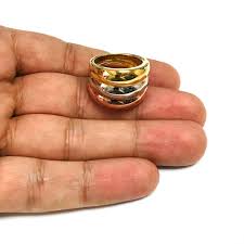 Gold silver and rose gold ring with three fused rings stacked on a hand