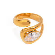 Gold ring with a horizontal clear marquis gemstone on a white background