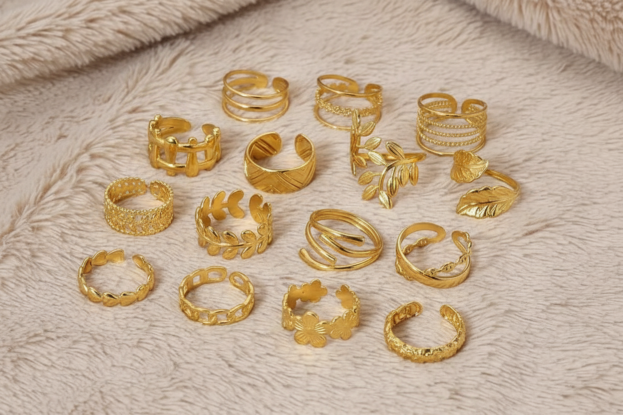 Collection of gold rings on a textured beige surface