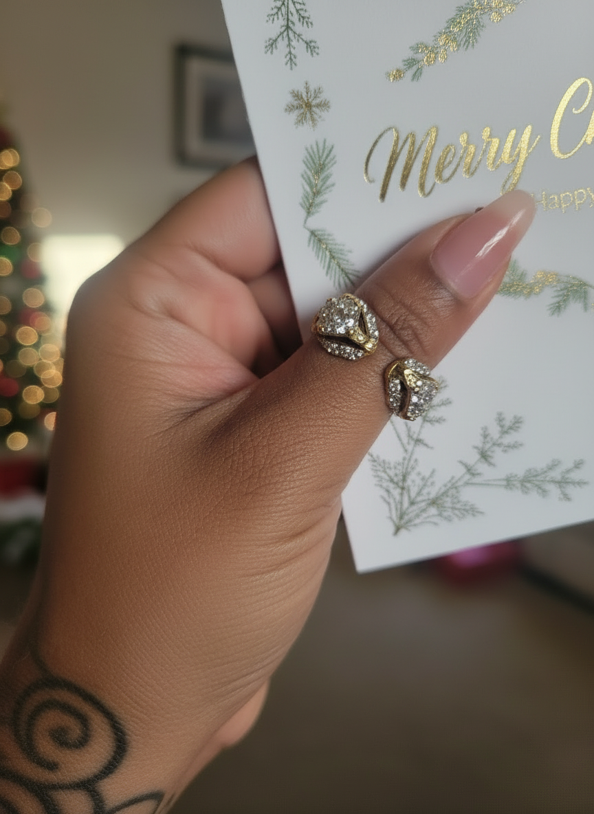 Hand with double Panther head open ring that has clear crystals all over the head and green crystals for eyes  holding a Christmas card with decorative text in a festive room